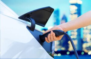 Person charging an electric vehicle in the city